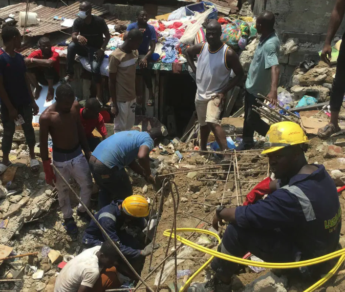 Equipes de resgate e populares tentam retirar crianças de escombros de prédio que abrigava escola primária em Lagos, capital financeira do país (Foto: AP Photo/Sunday Alamba)