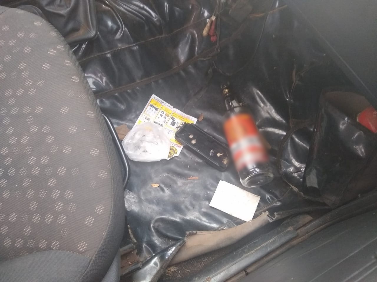 Garrafa de bebida alcoólica encontrada dentro do veículo (Foto: Divulgação/PM)