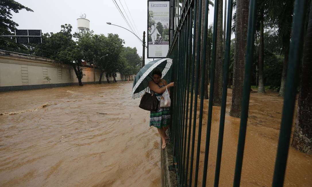 Mulher tenta passar pela rua alagada. A Rua Jardim Botânico foi uma das mais afetadas pelas chuvas (Foto: Pablo Jacob / Agência O Globo)