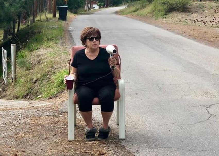 A idosa aponta um secador de cabelo para a rodovia e os carros diminuem a velocidade (Foto: Reprodução)