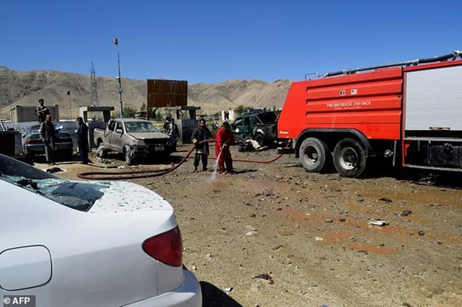 Bombeiro afegão joga água no local onde ocorreu um ataque suicida, que teve como alvo uma manifestação de campanha do presidente afegão (Foto: Reprodução/Daily Mail)