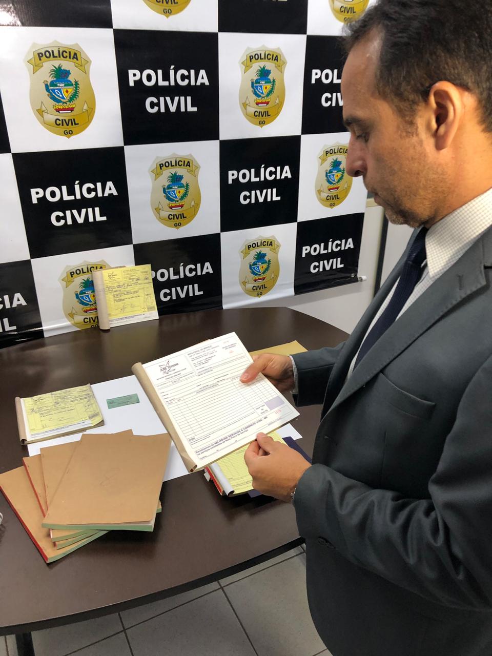 Delegado inspeciona documentos que, segundo investigações, são provas de crimes tributários