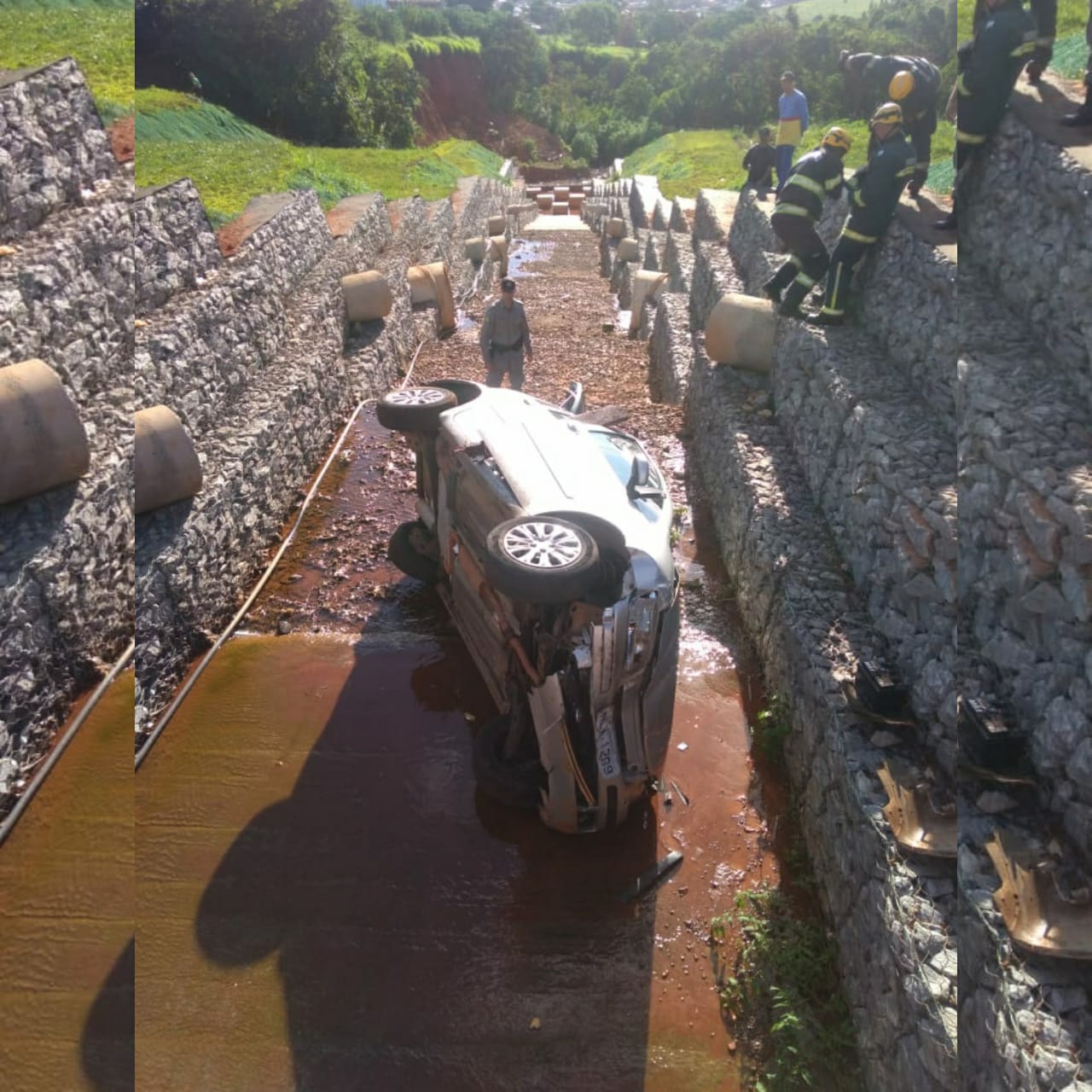 Uma mulher ficou ferida após o carro em que estava cair em uma rede de escoamento de aproximadamente 10 m depois de se envolver em um acidente. (Foto: Divulgação/Corpo de Bombeiros)