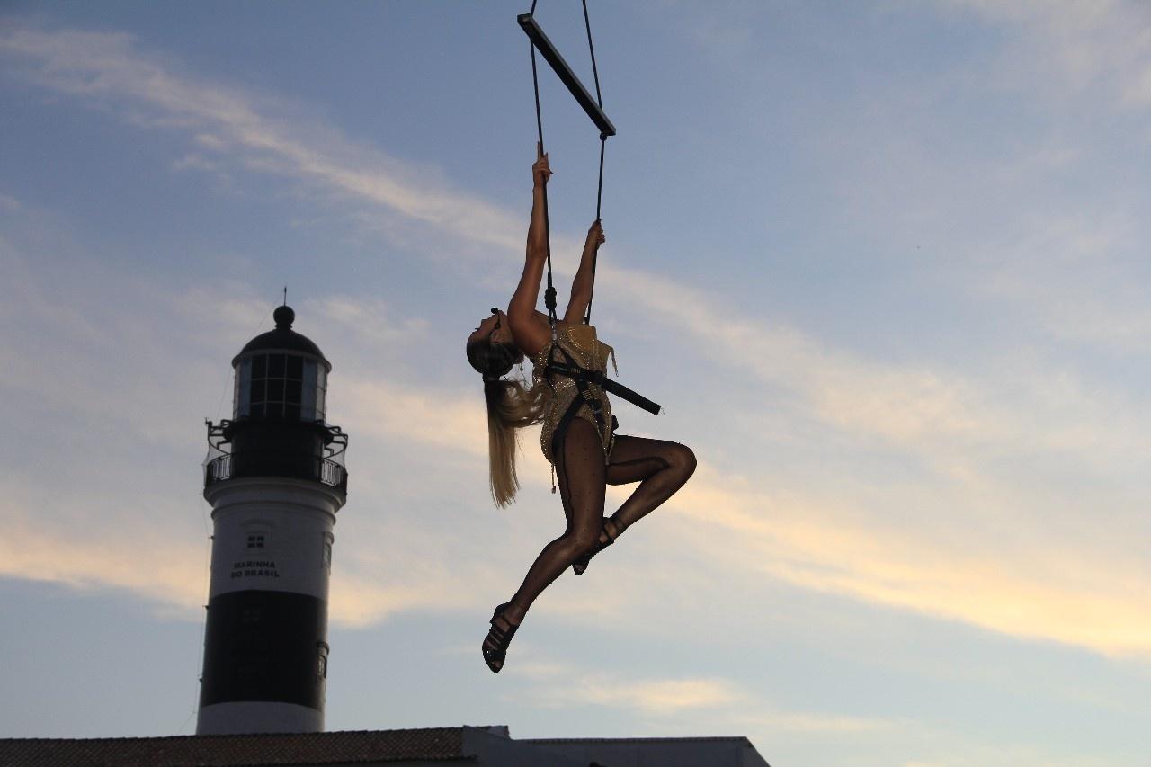 Claudia Leitte se enrola com microfone ao ficar pendurada em show