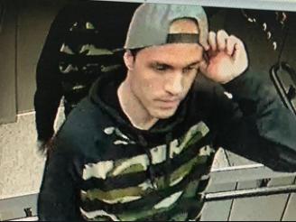 Homem no elevador mexe no boné