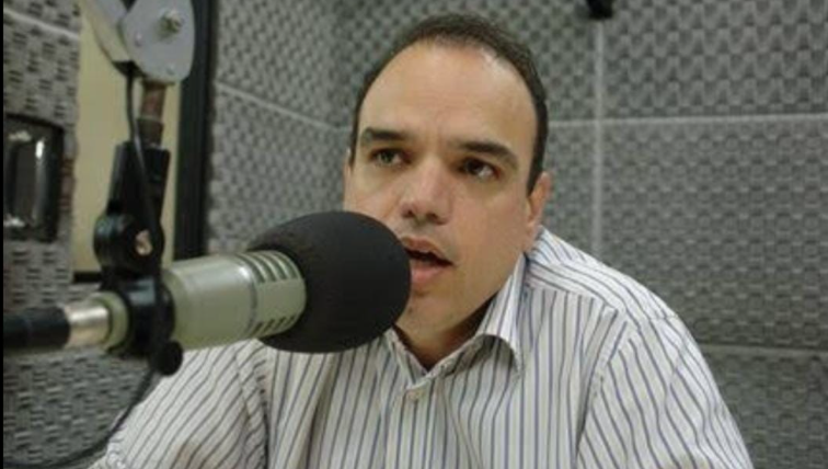 Homem fala em frente ao microfone