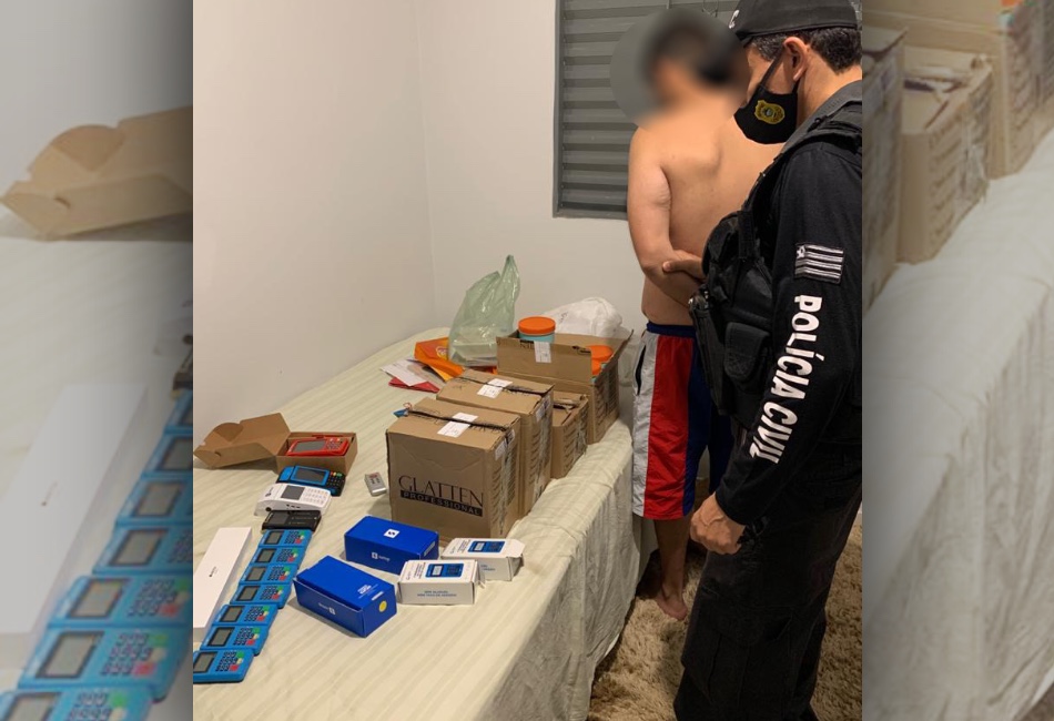 Um dos suspeitos presos na operação Card Seeking, com as máquinas de cartão que ele usava. Foto: Polícia Civil