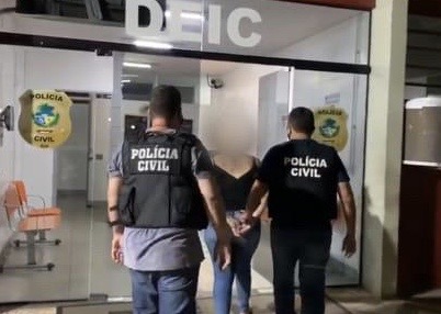 Polícia conduz uma das suspeitas à delegacia (Foto: Polícia Civil)