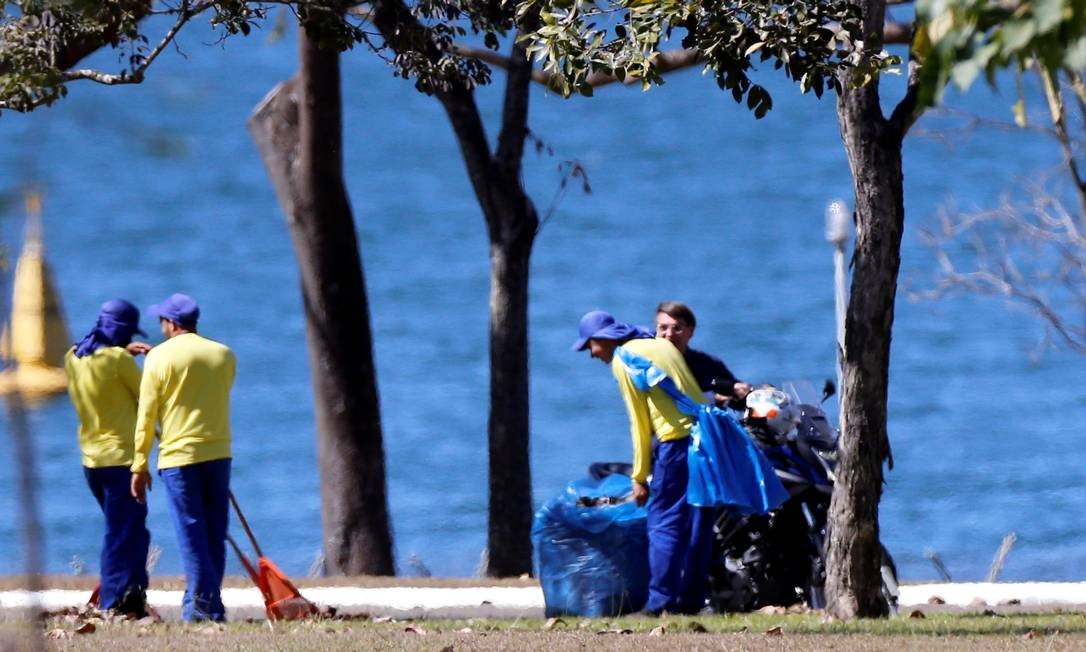 O presidente Jair Bolsonaro passeou de moto no Palácio da Alvorada e conversou, sem máscaras, com garis que faziam a limpeza do local. (Foto: Adriano Machado/Reuters)