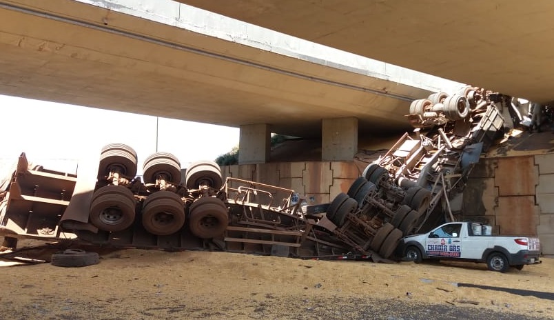 Carreta com 40 toneladas de milho cai de viaduto sobre carro, em Itumbiara
