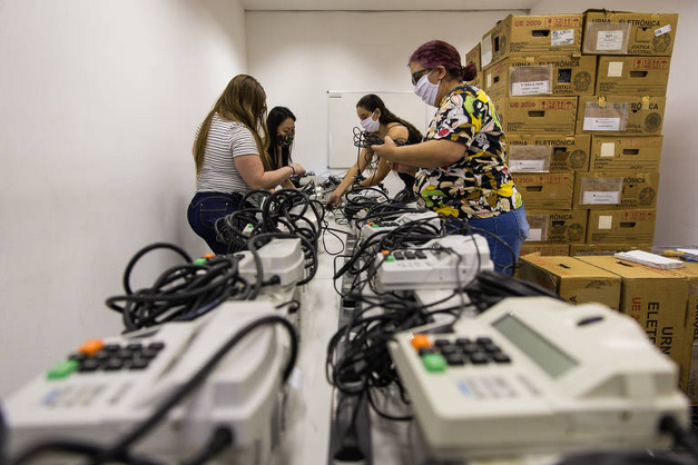 Servidores das Justiça Eleitoral ajustam urnas, na Bela Vista, em São Paulo (Foto: Zanone Fraissat / Folhapress)