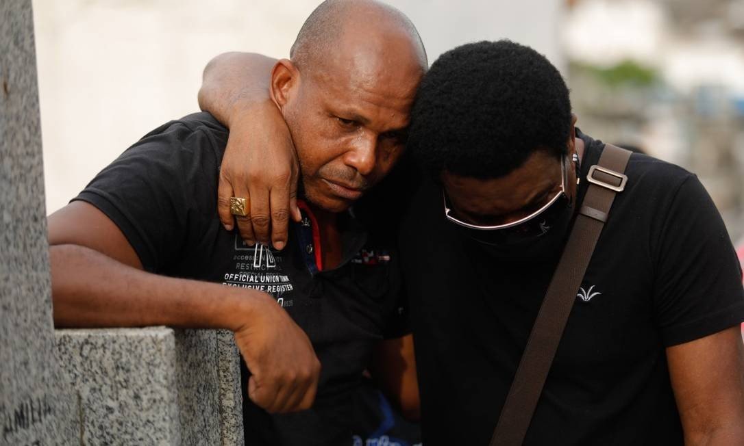 Neguinho da Beija-Flor consola o filho, Paulo Cesar, durante o enterro do corpo de Gabriel Foto: Brenno Carvalho / Agência O Globo