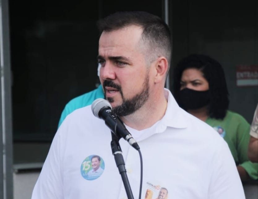 Gustavo Mendanha no microfone com adesivo da Maguito Vilela na camisa