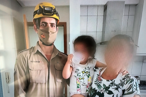 Bombeiro ao lado da criança que ele ajudou a resgatar e a mãe dela (Foto: Reprodução)