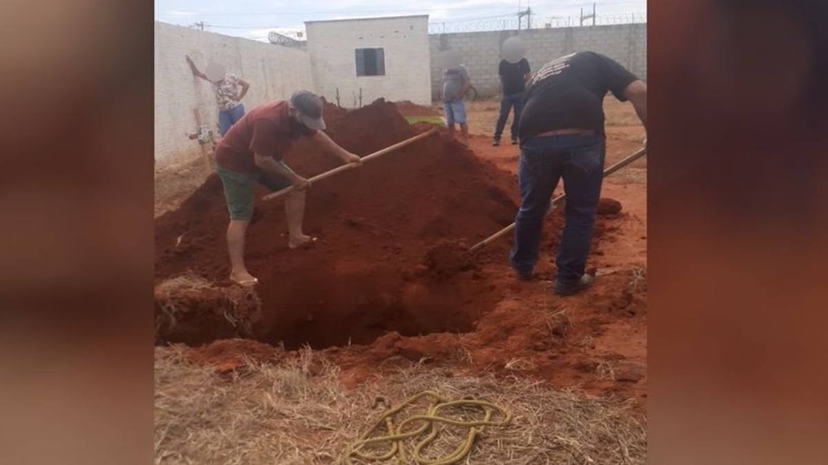 Um coveiro foi flagrado de bermuda e chinelo ao sepultar uma vítima de Covid-19 em Campinorte. (Foto: reprodução/redes sociais)