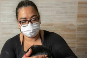 Mulher sustenta família ao virar catadora de piolho profissional em SP