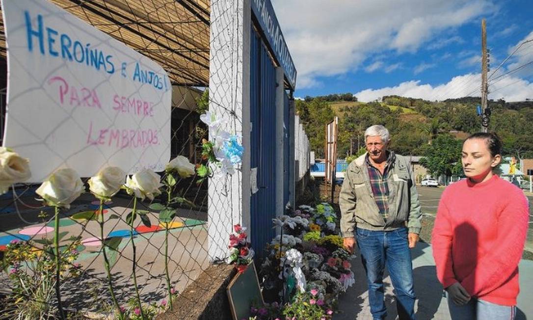 Ailton Biazebetti e a filha Aline Biazebetti, vizinhos da escola, ajudaram a salvar uma criança levando-a para o hospital (Foto: Edilson Dantas/ reprodução/O Globo)