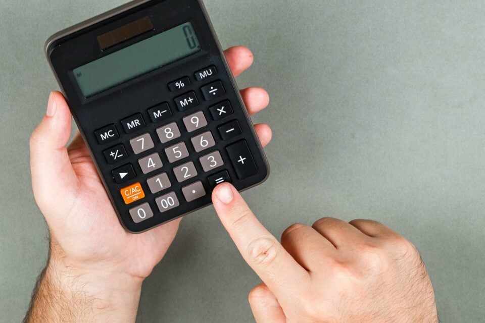 Accounting and calculation concept on gray background top view. someone calculating something. horizontal image