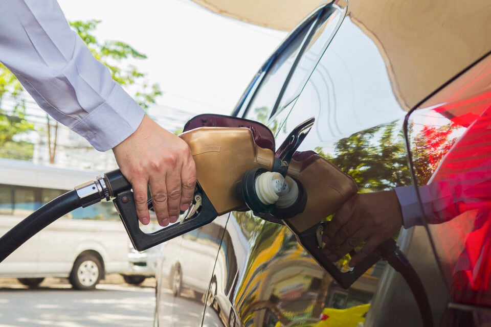 Man putting gasoline fuel into his car in a pump gas station