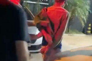 Imagem mostra suspeito sendo levado algemado para delegacia. Foto ilustra chamada: Jovem descumpre medida protetiva e ameaça mãe e irmã gestante em Jaraguá