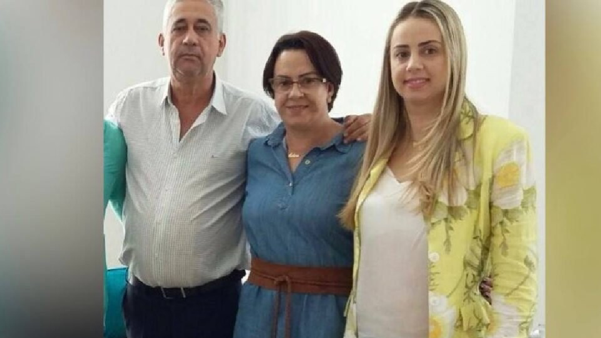 O pai à esquerda, a mãe no meio e a filha na outra extremidade posam para a foto. As duas mulheres sorriem e o homem se mantém sério. Foto ilustra a chamada: Família vítima de triplo homicídio no Paraná é enterrada em Pires do Rio