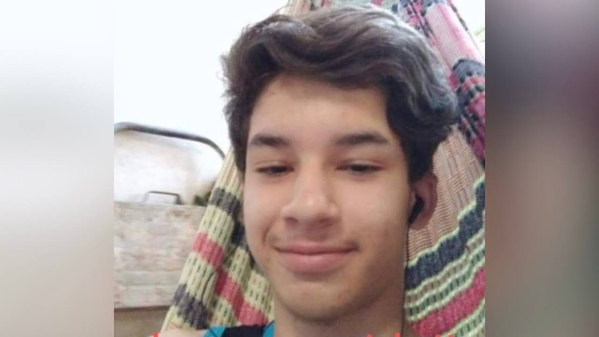 Menino aparecendo esboçando um rosto feliz, sem sorrir em selfie. 