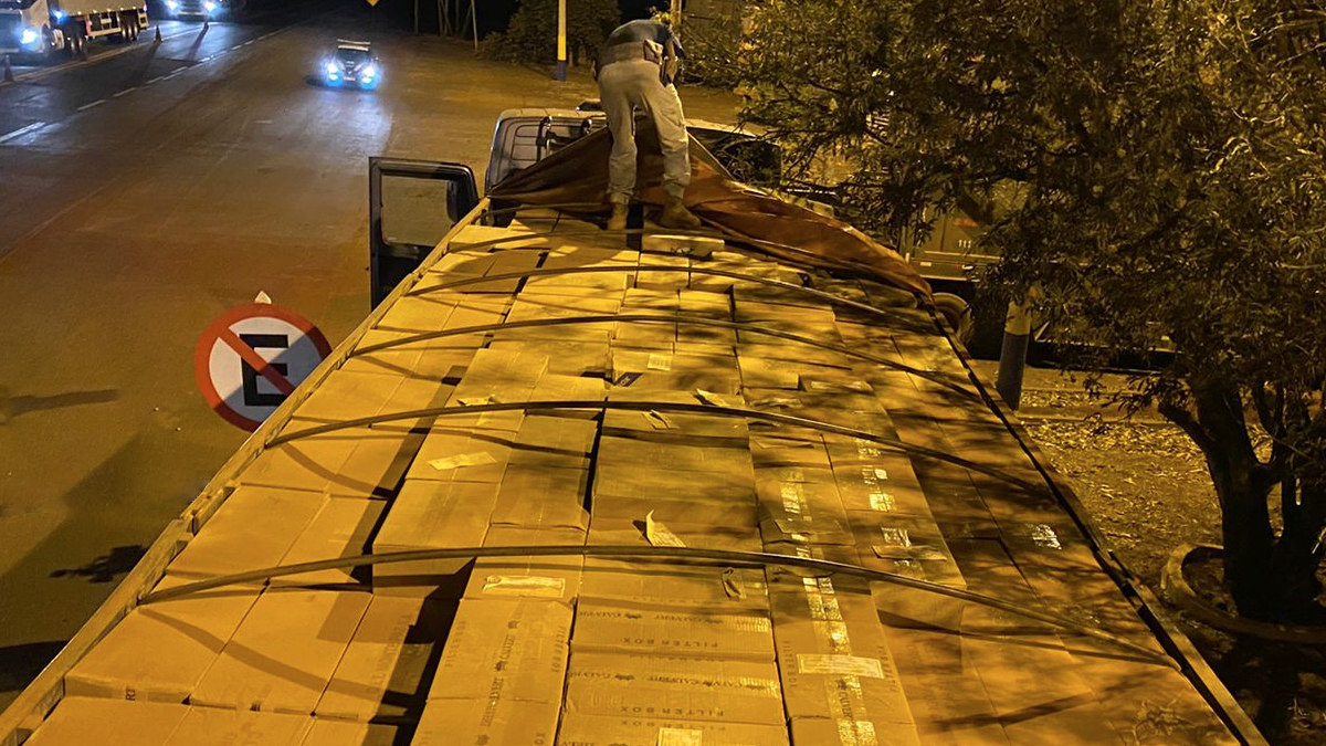 Caminhão carregado com caixas. Dentro dela existem 420 mil maços de cigarros contrabandeados. Ao lado do caminhão está uma placa de proibido estacionado. Foto ilustra chamada: Polícia apreende R$ 2.1 milhões em cigarros contrabandeados em Santa Rita do Araguaia