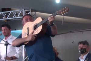 Jair com viola entregue pelo cantor Amado Batista - Bolsonaro afirmou em discurso que "homem armado jamais será escravizado". Ele está por evento na Assembleia de Deus Campinas