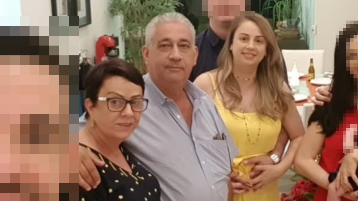 Família posa para uma selfie com outras pessoas, que foram ocultadas deste recorte. Apenas a filha sorri para a foto. O casal fica sério, como quem não percebeu o momento do registro.