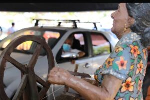 Escultura de uma mulher fazendo renda