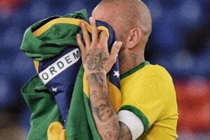 Daniel Alves com a bandeira do Brasil no rosto