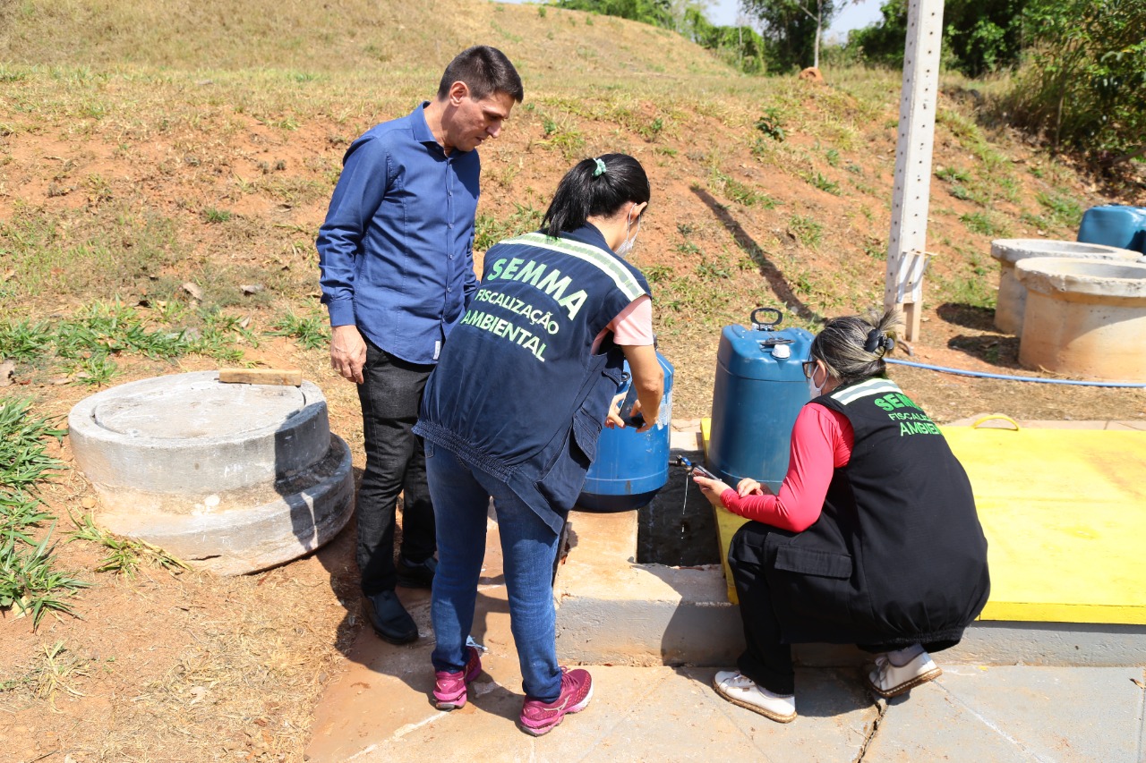 Fiscais do Meio Ambeinte recolhem amostras de água em galões