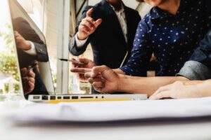 Pessoas trabalham em escritório e checam informações em laptop - O número de novas empresas abertas em Goiás entre janeiro e setembro de 2021 é de 25.924