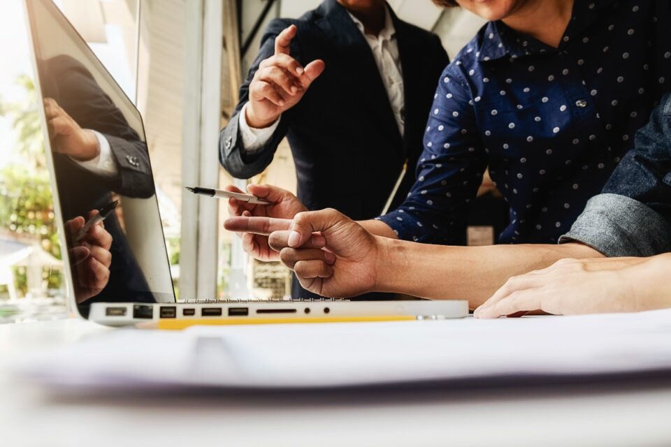 Pessoas trabalham em escritório e checam informações em laptop - O número de novas empresas abertas em Goiás entre janeiro e setembro de 2021 é de 25.924