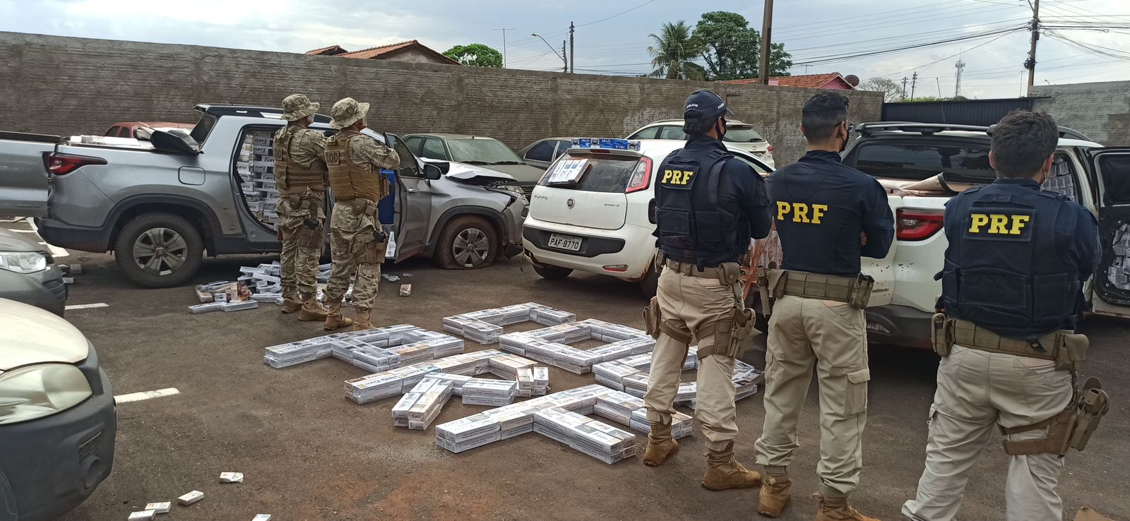 Policiais posam com a carga de cigarro contrabandeado apreendida - 50 mil maços de cigarros