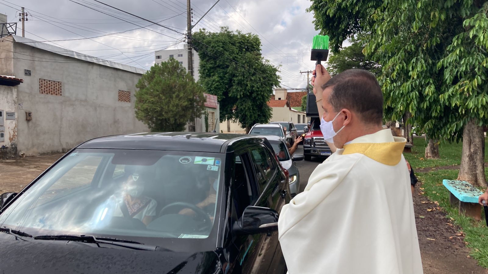 Padre borrifa água benta em "drive-thru" de bênçãos em Goiânia