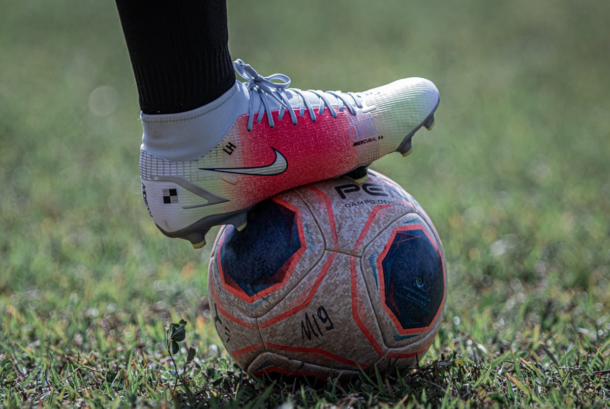 Jogador com bola de futebol no pé