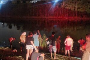 Pessoas à volta da represa enquanto bombeiros realizam resgate