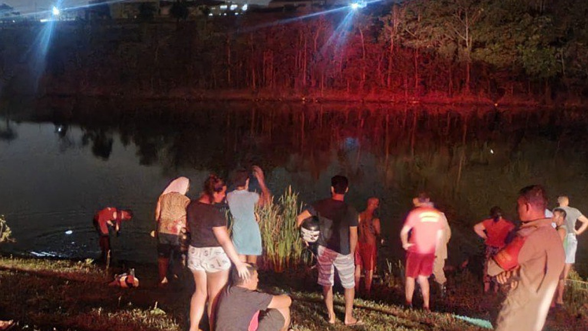 Pessoas à volta da represa enquanto bombeiros realizam resgate