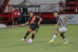 Janderson tenta o drible no jogador do Atlético-MG