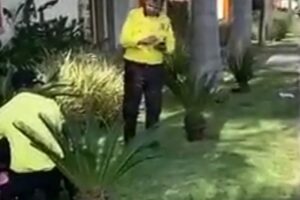 Agentes de trânsito segurando um motociclista no chão