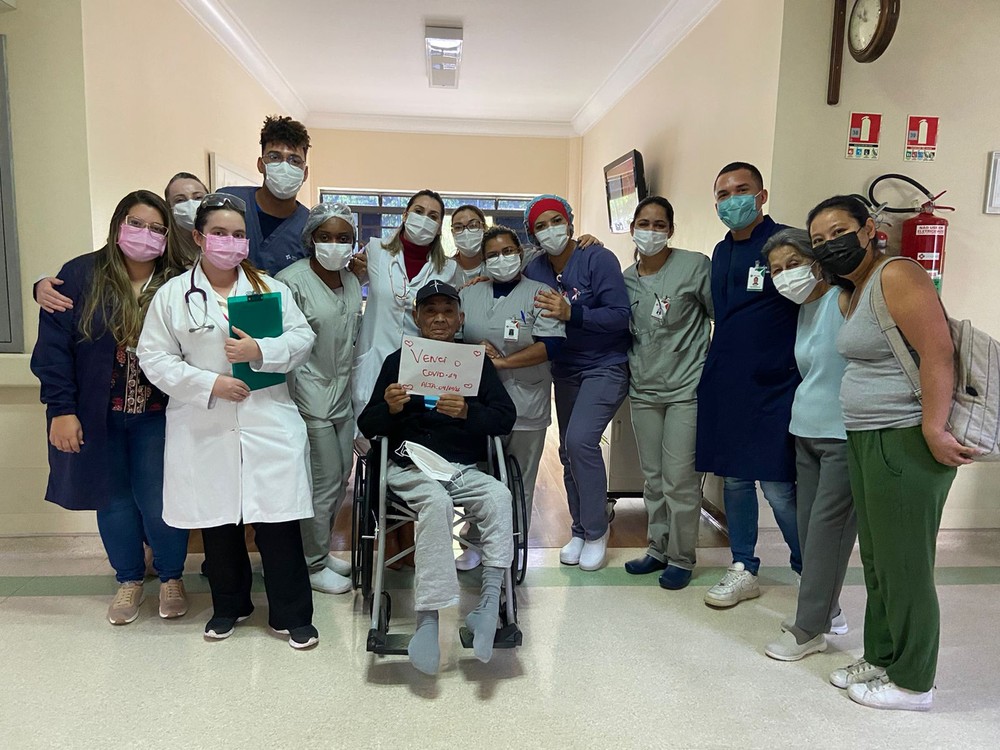 Carlos Massatoshi Higa posa com equipe do Hospital São Camilo, na Zona Norte, onde ficou internado por 191 dias devido à Covid-19