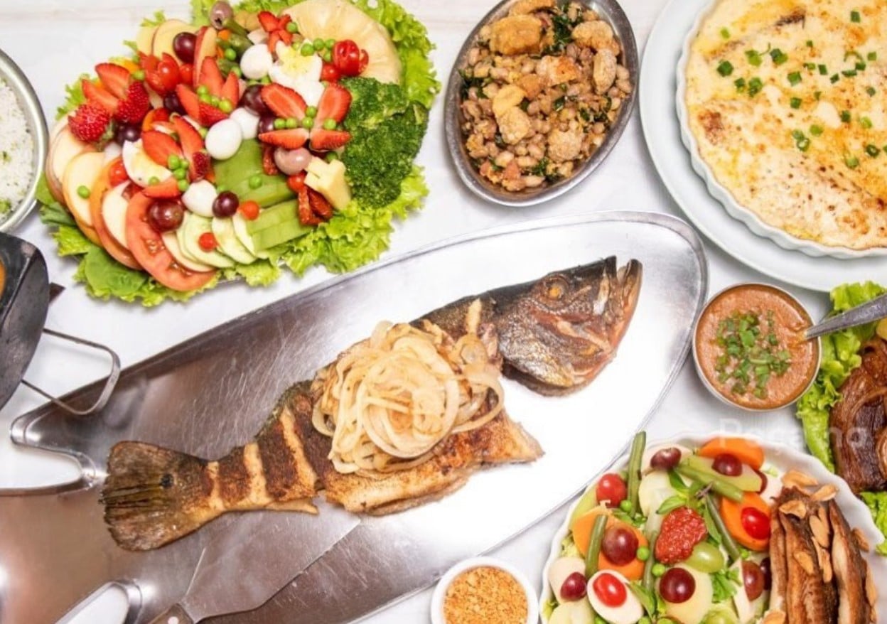 peixe servido com arroz, feijão tropeiro e saladas