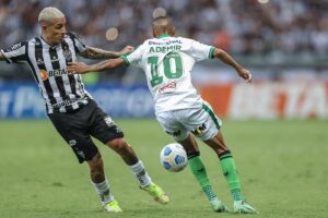 Guilherme Arana tenta passar pela marcação do jogador do América-MG