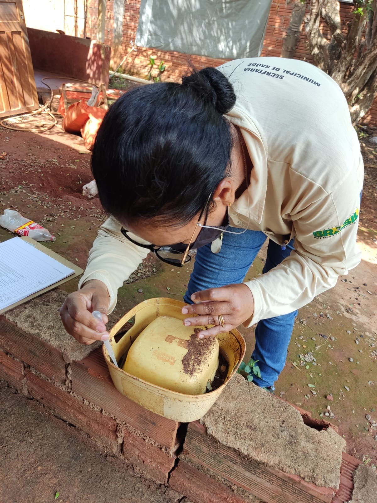 Agente do centro de endemias colhe material de reservatório. (Foto: Divulgação)