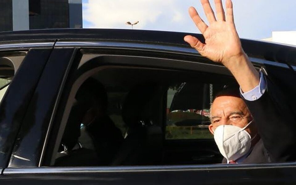 Iris Rezende de máscara acenando como um adeus de dentro de carro