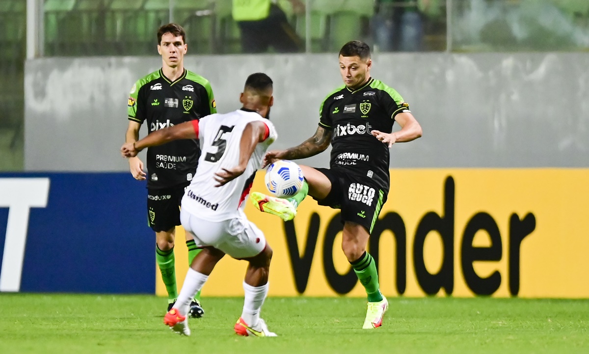 Willian Maranhão tenta tomar a bola do jogador do América-MG