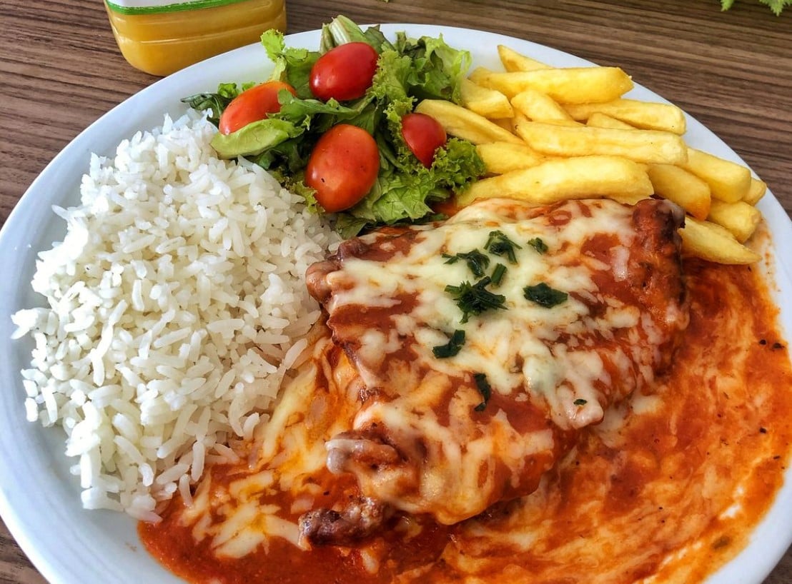 prato com arroz, salada de tomate e alface, batata frita e parmegiana de filé mignon do restaurante Rei do Parmegiana, opção para comprar parmegiana em Goiânia