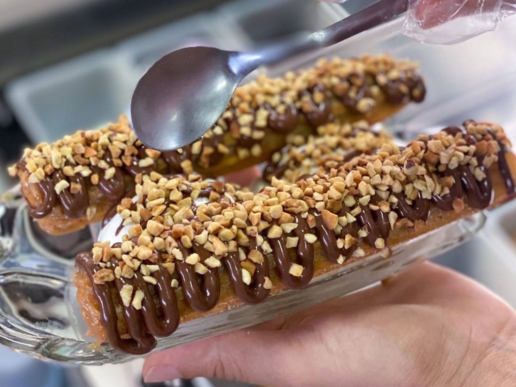 dois churros com cobertura de chocolate e amendoim, do Churros da Calais, opção para comprar churros em Goiânia