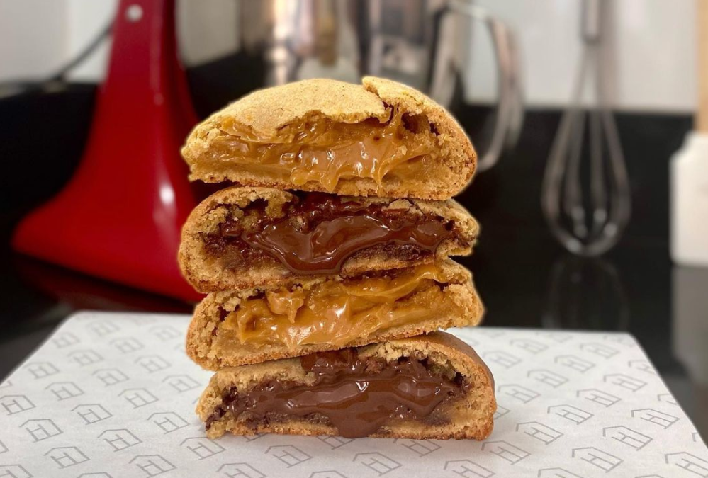 quatro cookies cortados ao meio e recheados com doce de leite e chocolate, empilhados e intercalados um sobre o outro. A foto é da Cookie House, opção para comprar cookies em Goiânia